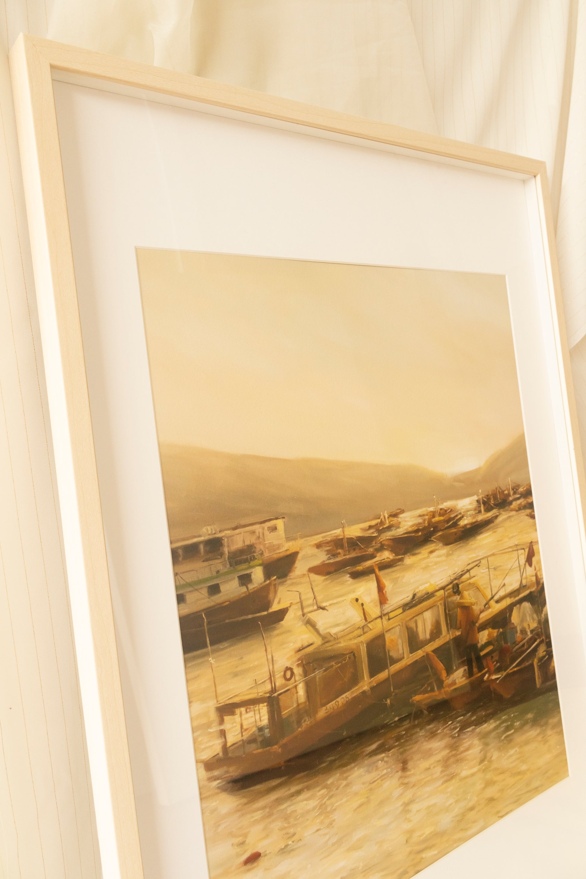 Side view. Limited edition art print titled 'Ocean Wanderers' featuring a serene seascape at dawn with fishing boats and a lone fisherman against a golden sunrise.